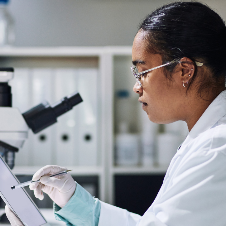 Picture of a female researcher using a microscope in a lab